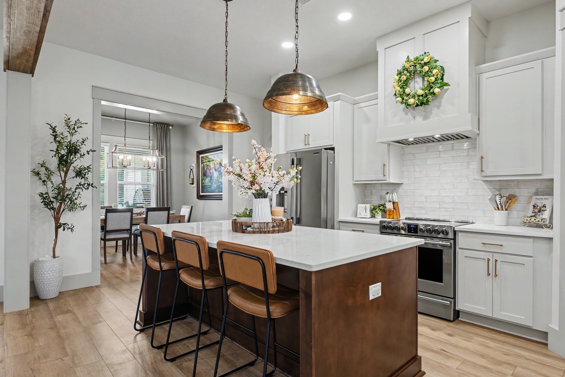 Designer kitchen with copper pendant lights, light wood floors, and a marble island — Jones Drive listing